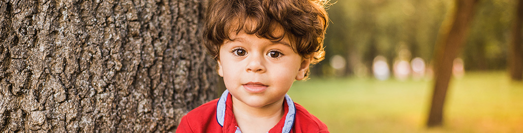 A kid next to a tree.