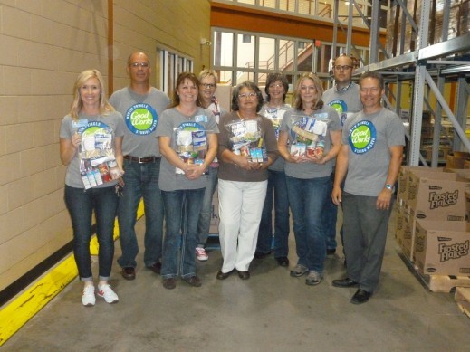 Martin Pringle GoodWorks volunteers show off the food they assembled for the Food-4-Kids program at the Kansas Food Bank.