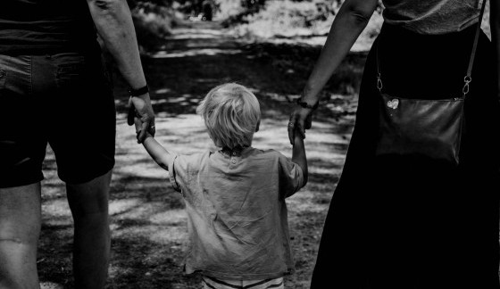 Photo of parents and child holding hands
